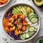Bang Bang Chicken Bowl with avocado, cucumber, shredded carrots, and red cabbage over white rice