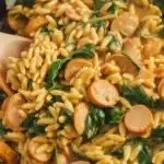 Creamy Chicken Sausage Orzo Skillet with vegetables and herbs in a large skillet.