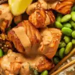 High Protein Low Calorie Crispy Bang Bang Salmon Bites with creamy sauce, edamame and rice.