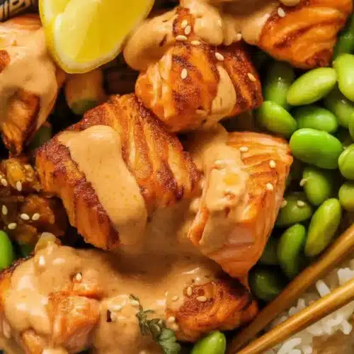 High Protein Low Calorie Crispy Bang Bang Salmon Bites with creamy sauce, edamame and rice.