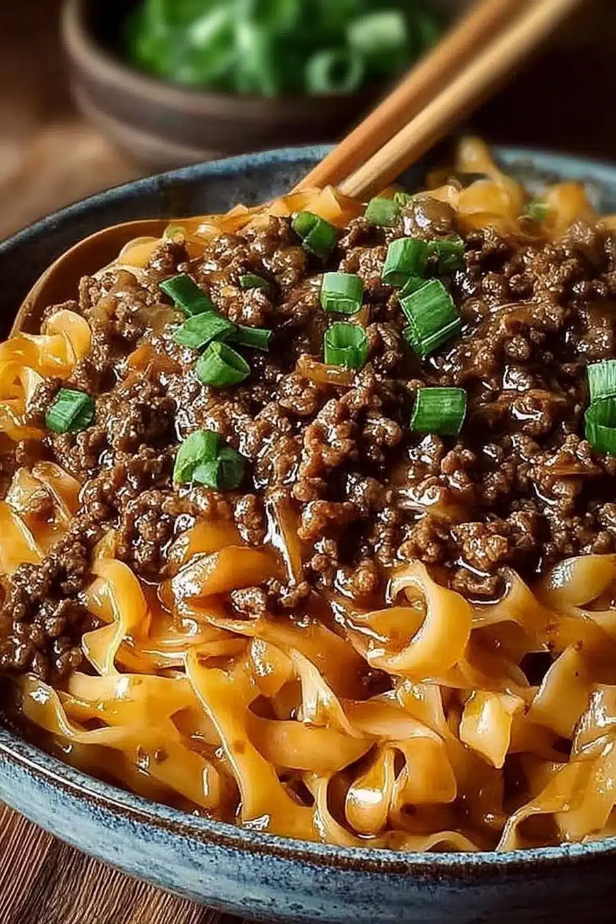Delicious Mongolian ground beef noodles served in a bowl with vegetables.