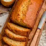 Loaf of homemade Southern Peach Bread with slices and fresh peaches
