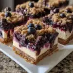 Delicious blueberry crisp cheesecake bars on a plate