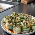 Chicken Salad Cucumber Rolls arranged on a plate, garnished with herbs.