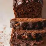 Slice of moist chocolate zucchini bread topped with chocolate chips