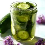 Jar of homemade no-cook refrigerator pickles with fresh vegetables.