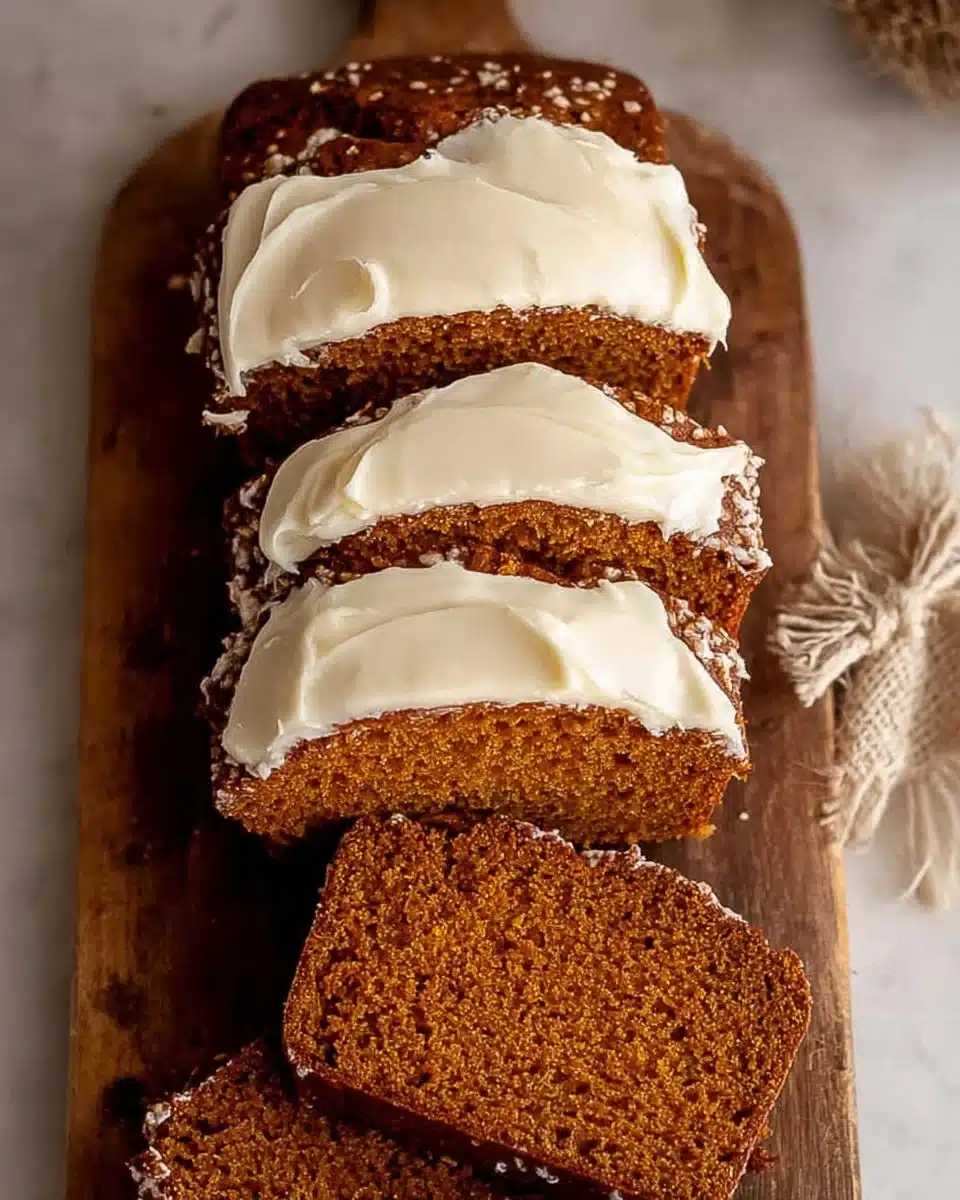Pumpkin bread with cream cheese frosting on a wooden table