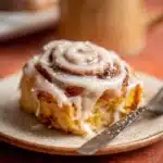 Freshly baked Pumpkin Cinnamon Rolls with cream glaze on top