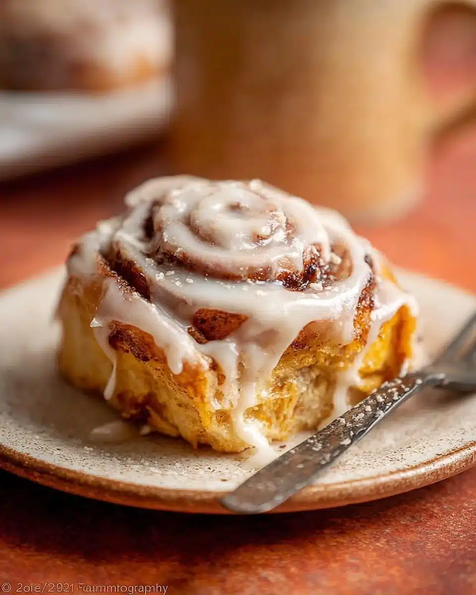 Freshly baked Pumpkin Cinnamon Rolls with cream glaze on top