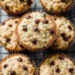 Freshly baked chocolate chip zucchini muffins on a wooden table.