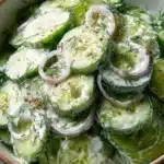 Creamy cucumber salad with fresh ingredients in a bowl
