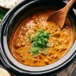 Delicious Crockpot Butter Chicken served with rice and garnished with cilantro.