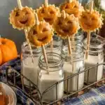 Jack o'Lantern Mini Pumpkin Pie Pops on a rustic wooden table