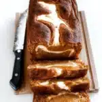 Loaf of homemade Pumpkin Cream Cheese Bread on a wooden table