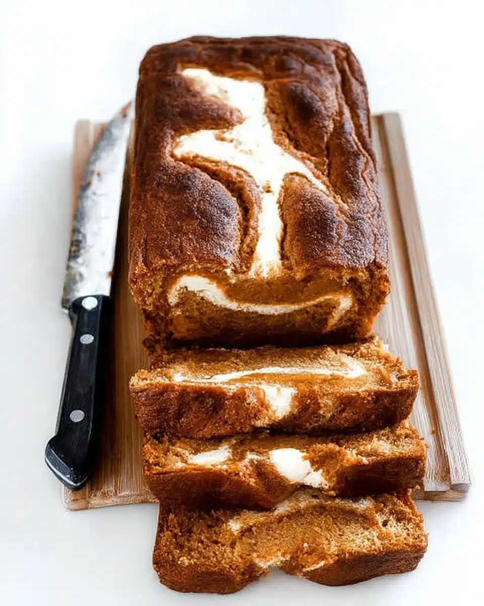 Loaf of homemade Pumpkin Cream Cheese Bread on a wooden table