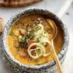 Creamy Pumpkin Leek Soup served in a bowl with herbs on top