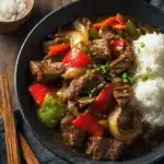 Slow cooker pepper steak served with bell peppers and rice