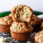 Freshly baked zucchini muffins on a rustic wooden table.