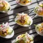 Plate of California Roll Deviled Eggs garnished with avocado and seafood