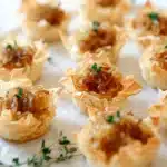 Caramelized onion tartlets topped with brie cheese, a delectable appetizer.