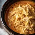 Delicious Crockpot Buffalo Ranch Chicken served in a bowl with garnishing.