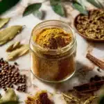Bowl of curry-inspired fall spice mix with colorful spices and herbs