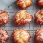 Freshly made glazed apple fritters on a plate