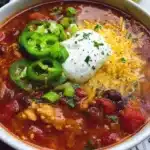 Bowl of healthy turkey chili topped with fresh cilantro and avocado