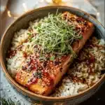 Honey glazed salmon bowl topped with fresh vegetables and garnished for presentation