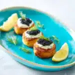 Mini salmon rissoles topped with sour cream and Attilus caviar
