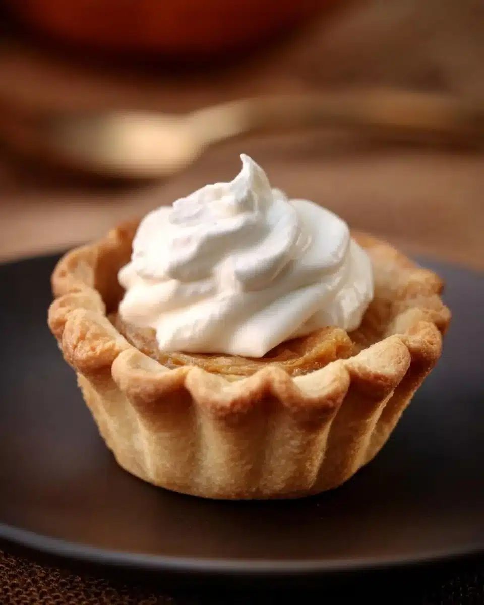 Muffin tin pumpkin pies on a decorative plate, perfect for fall desserts.