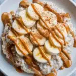 Bowl of oatmeal topped with banana slices and a dollop of peanut butter