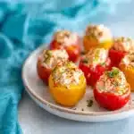 Plate of colorful stuffed cherry tomatoes filled with herbs and cheese