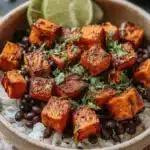 Sweet potato and black bean bowl topped with fresh vegetables.