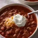 Classic homemade chili served in a bowl, garnished with herbs.