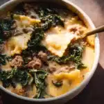 Creamy white lasagna soup in a bowl with fresh herbs