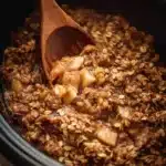 Delicious Crock Pot apple crisp with a golden topping and fresh apples