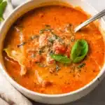 Bowl of creamy lasagna soup topped with cheese and herbs.
