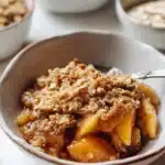 Gluten free apple crisp dessert with oats and apples in a baking dish