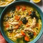 Bowl of Lemon Chicken Orzo Soup garnished with parsley