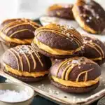 Delicious salted caramel whoopie pies on a plate with a drizzle of caramel sauce