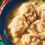 Delicious chicken and dumplings served in a bowl with herbs