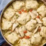 A bowl of homemade Chicken and Dumplings with herbs and spices