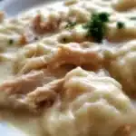 Bowl of homemade cracker barrel-style chicken and dumplings with herbs