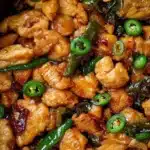 Plate of spicy jalapeño chicken garnished with herbs and served with rice.