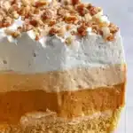 No Bake Triple Layer Pumpkin Spice Pudding Pie topped with whipped cream and spices