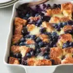 Quick blueberry french toast casserole topped with fresh blueberries and syrup