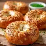 Three delicious homemade cottage cheese bagels on a plate.
