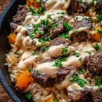 Cheesy Steak and Rice Skillet served in a frying pan with melted cheese