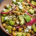 Chickpea Feta Avocado Salad with fresh ingredients on a wooden table.